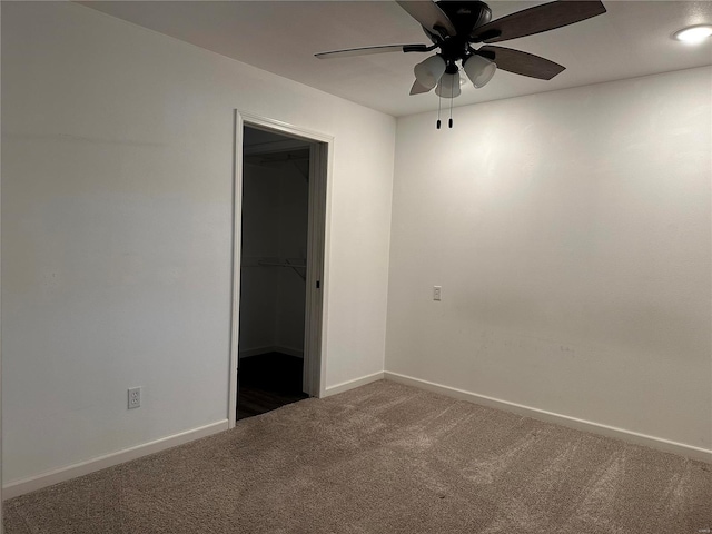 empty room featuring dark colored carpet and ceiling fan