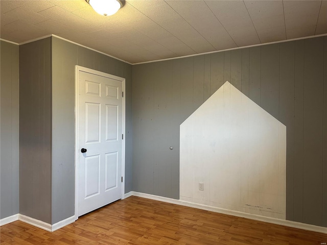 bonus room featuring wood walls and light hardwood / wood-style flooring