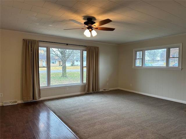 unfurnished room featuring dark hardwood / wood-style floors, plenty of natural light, ornamental molding, and ceiling fan