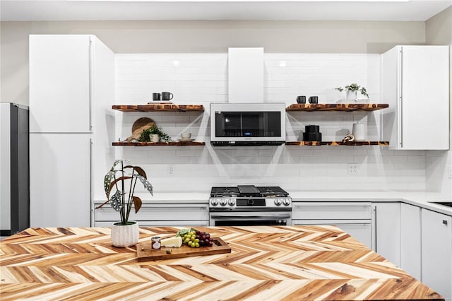 kitchen featuring backsplash, white cabinetry, and stainless steel appliances