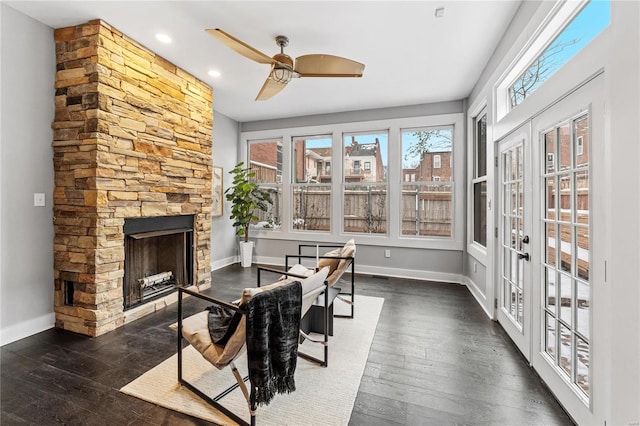 sunroom featuring ceiling fan, a fireplace, and french doors