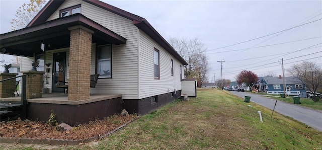 view of property exterior featuring a lawn and covered porch