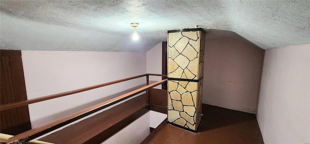 interior space featuring a textured ceiling and lofted ceiling