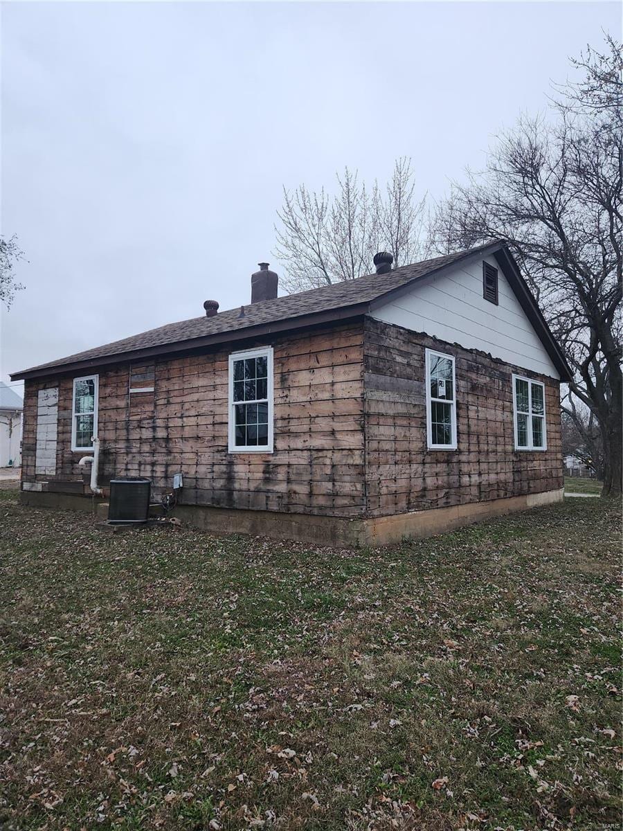 view of home's exterior with a yard and central AC