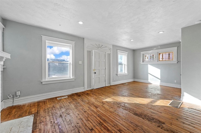 foyer entrance with wood-type flooring and a textured ceiling