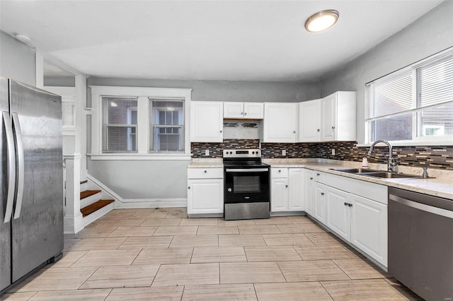 kitchen with white cabinets, stainless steel appliances, and tasteful backsplash