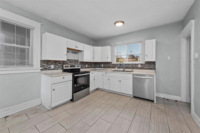 kitchen with appliances with stainless steel finishes, tasteful backsplash, white cabinetry, and sink