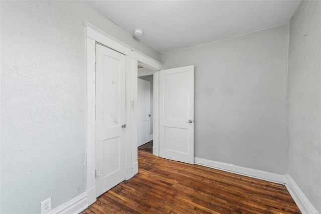 unfurnished bedroom with dark wood-type flooring