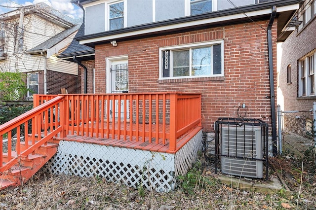 rear view of house with cooling unit and a wooden deck