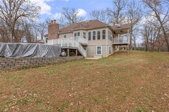 rear view of house with a wooden deck and a yard