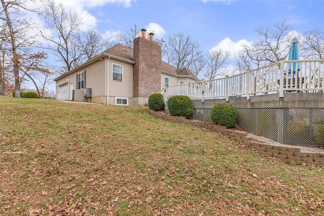 view of property exterior with a yard, a garage, and a wooden deck