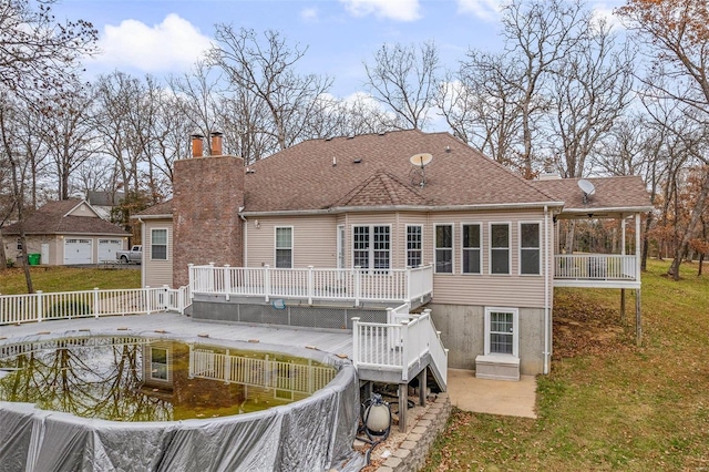 rear view of property featuring a deck and a yard