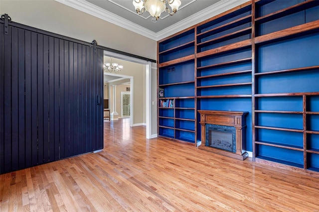 unfurnished living room featuring hardwood / wood-style floors, a notable chandelier, and a barn door