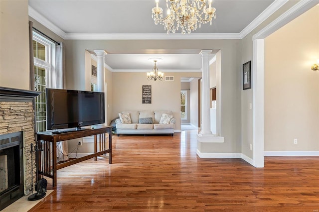 living room featuring decorative columns, hardwood / wood-style floors, and a healthy amount of sunlight