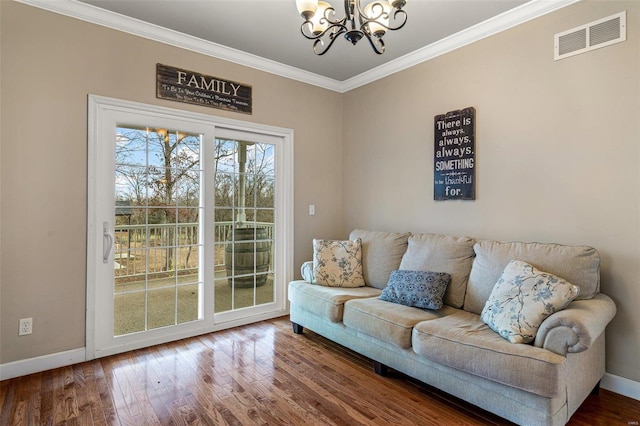 living room with hardwood / wood-style floors, an inviting chandelier, and ornamental molding