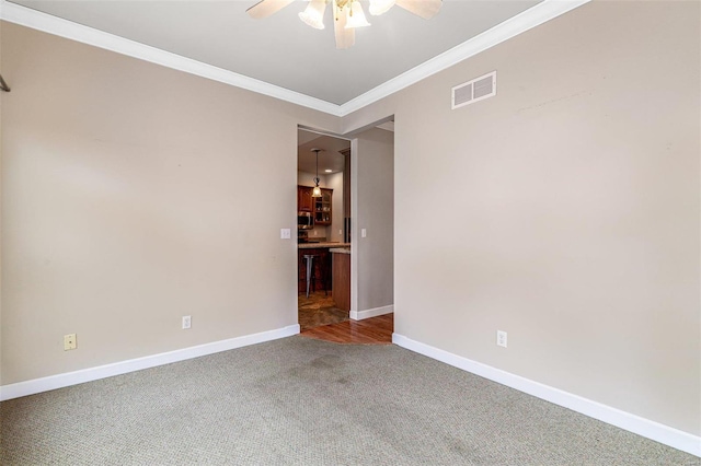 empty room with carpet, ceiling fan, and ornamental molding