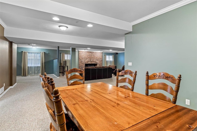 dining area featuring carpet, ornamental molding, and a brick fireplace