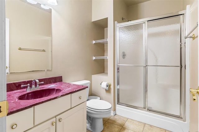 bathroom with tile patterned floors, vanity, toilet, and a shower with shower door