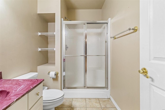 bathroom with tile patterned floors, vanity, toilet, and walk in shower