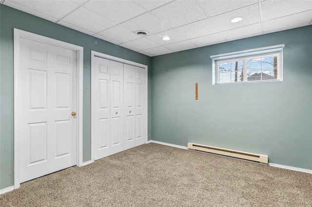 unfurnished bedroom featuring a closet, carpet floors, and a baseboard heating unit