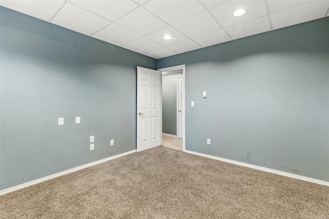 carpeted empty room featuring a paneled ceiling