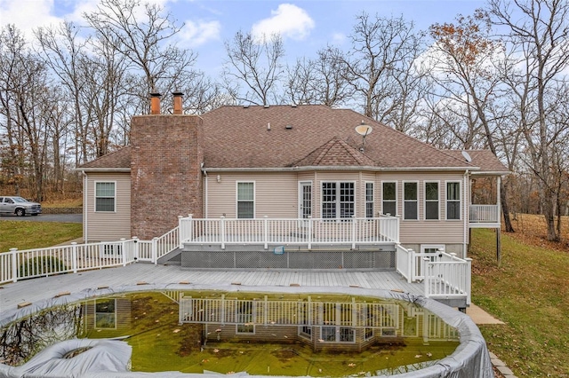 rear view of house featuring a lawn and a deck