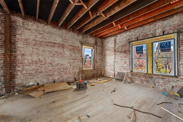 miscellaneous room with brick wall and a wealth of natural light