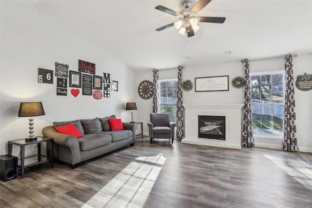 living room with a fireplace, ceiling fan, dark hardwood / wood-style floors, and lofted ceiling