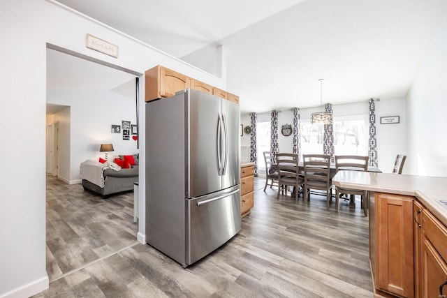 kitchen with decorative light fixtures, stainless steel fridge, and light hardwood / wood-style flooring