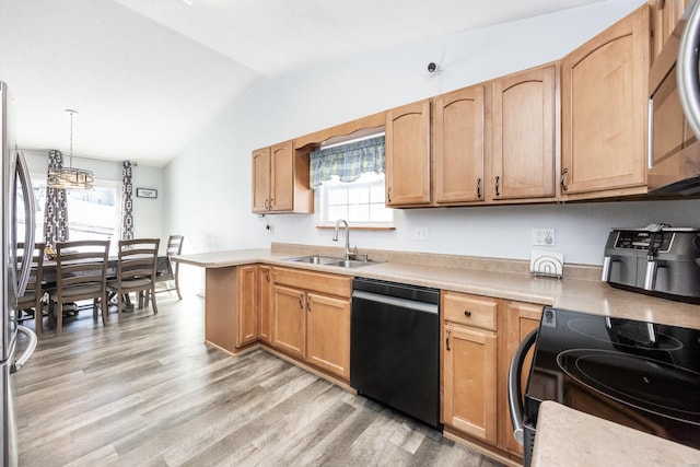 kitchen featuring lofted ceiling, light hardwood / wood-style floors, pendant lighting, sink, and appliances with stainless steel finishes