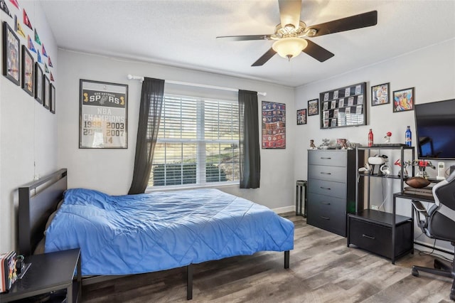 bedroom with a textured ceiling, ceiling fan, and hardwood / wood-style flooring