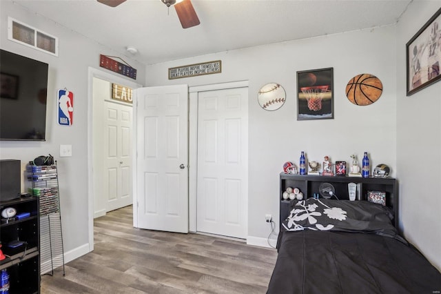 bedroom featuring ceiling fan, a closet, and hardwood / wood-style floors