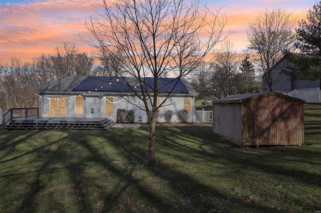 yard at dusk featuring a wooden deck and a storage shed