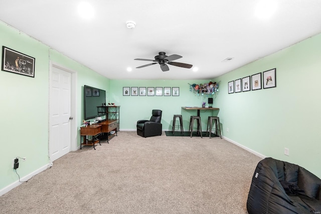 living area featuring carpet floors and ceiling fan