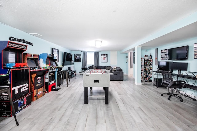 rec room featuring light hardwood / wood-style floors and a textured ceiling