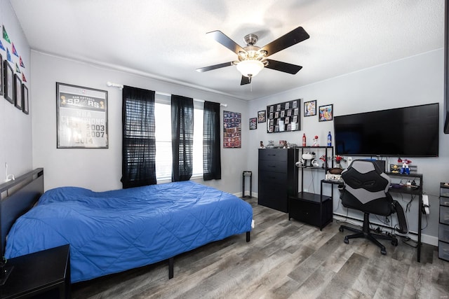 bedroom with a textured ceiling, ceiling fan, and hardwood / wood-style flooring