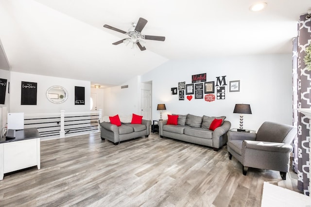 living room with ceiling fan, vaulted ceiling, and light hardwood / wood-style flooring