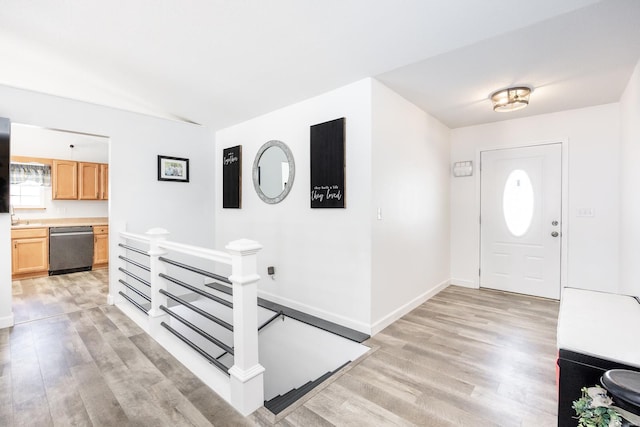 foyer with light hardwood / wood-style floors and sink