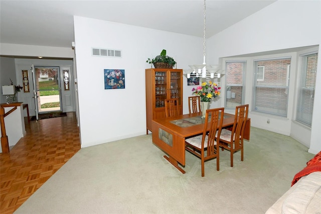 dining space with lofted ceiling, parquet floors, and a chandelier