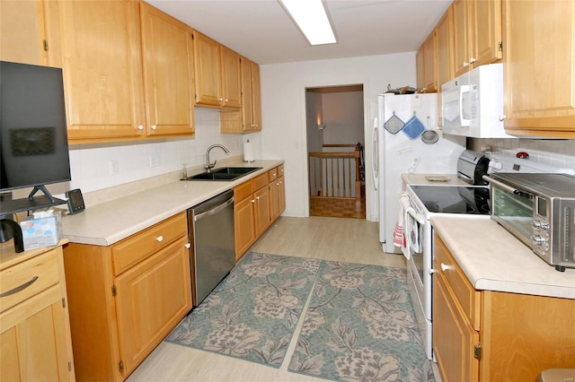 kitchen with decorative backsplash, sink, light hardwood / wood-style floors, and white appliances