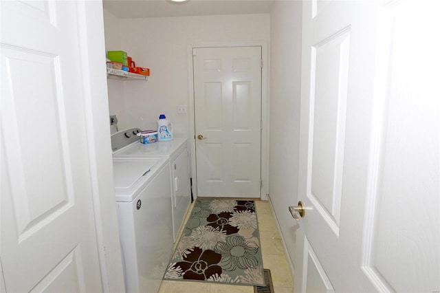 clothes washing area featuring light tile patterned floors and washing machine and dryer