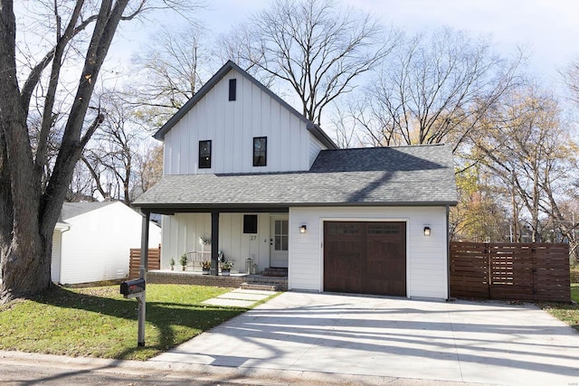 modern farmhouse style home with a front yard, a garage, and covered porch