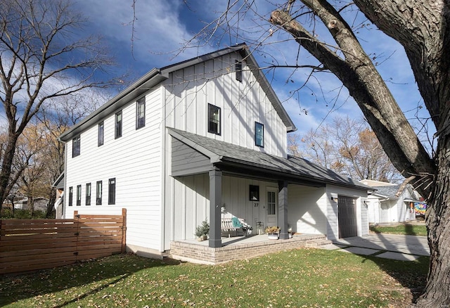 rear view of property with a lawn and a garage