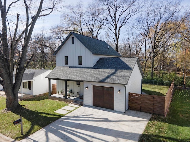 modern farmhouse with a front lawn and a garage