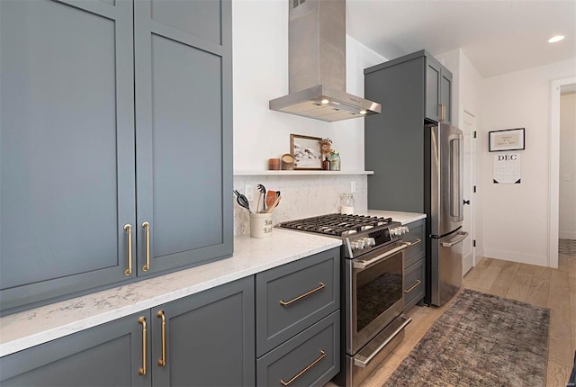 kitchen featuring backsplash, wall chimney exhaust hood, light hardwood / wood-style flooring, high quality appliances, and gray cabinets