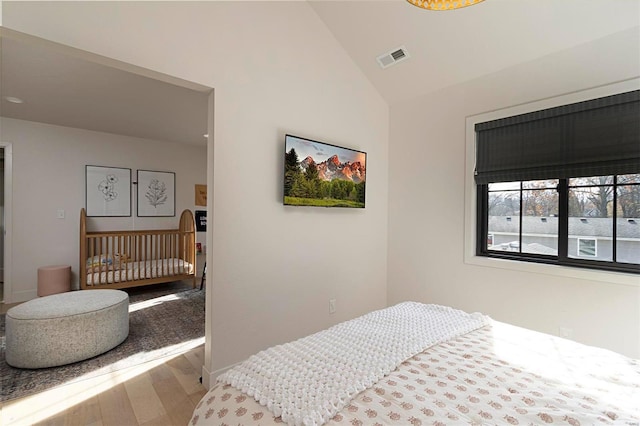 bedroom featuring hardwood / wood-style floors and vaulted ceiling