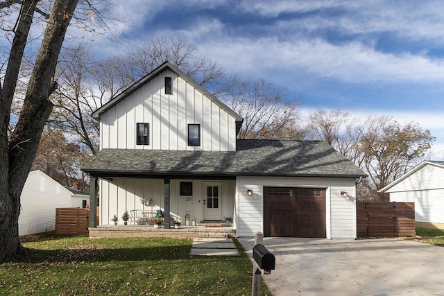 modern inspired farmhouse featuring a front yard, a porch, and a garage