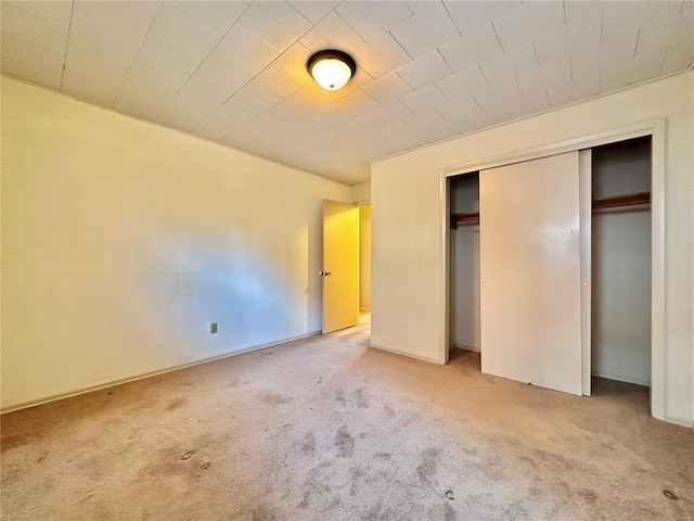 unfurnished bedroom featuring carpet and a closet