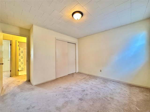 unfurnished bedroom featuring carpet flooring and a closet