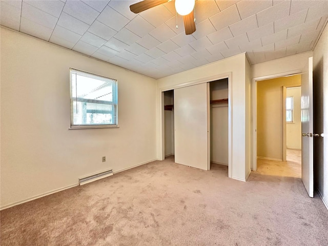 unfurnished bedroom with ceiling fan, a closet, and carpet